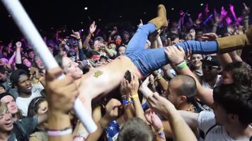 Topless crowd-surfing at a festival